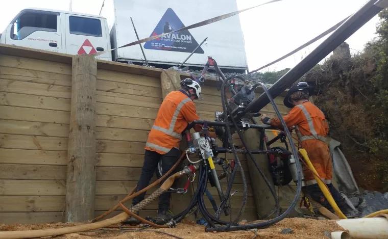 Avalon team members with retaining wall and heavy equipment